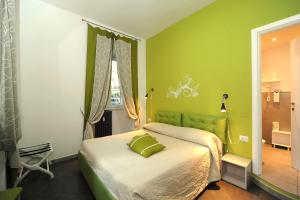 ein grünes Schlafzimmer mit einem Bett und einem Fenster in der Unterkunft OneTime Roma in Rom