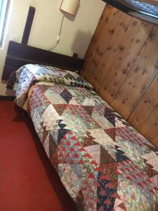 Bett in einem Zimmer mit einer Decke darauf in der Unterkunft Villa Borca di Cadore in Borca di Cadore