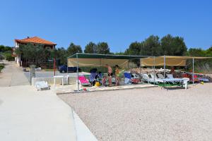 a group of people standing under a tent on a beach at Apartmani Nena in Ždrelac