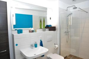 a white bathroom with a sink and a shower at Apartments am Freizeitpark in Kriftel +21 photos