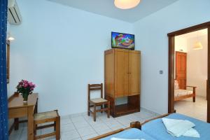 a bedroom with a bed and a table and a mirror at San Antonio Apartments in Kolymvari