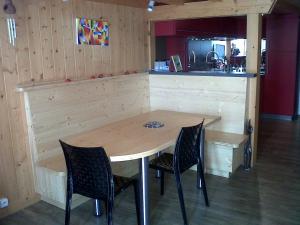 einen Holztisch mit zwei Stühlen und einer Theke in der Unterkunft Flaine Forum i1 Cassiopée Duplex Mezzanines & Terrasse in Flaine