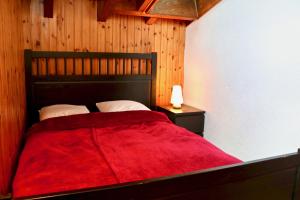 a bedroom with a bed with a red blanket at Au centre d'Ovronnaz - Chalet mitoyen in Ovronnaz