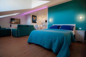 a blue bedroom with a bed and two green chairs at Los Rodeos Luxury Vivienda Vacacional in La Laguna