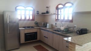 eine Küche mit Kühlschrank und Spüle in der Unterkunft Maravilhosa Villa com Piscina in Arraial do Cabo