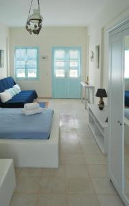 a bedroom with two beds and a blue door at Aeolis Santorini in Perissa
