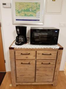 a microwave sitting on top of a wooden cabinet at Nigritella in Kranjska Gora
