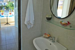 a bathroom with a sink and a mirror at Aeolis Santorini in Perissa +40 photos