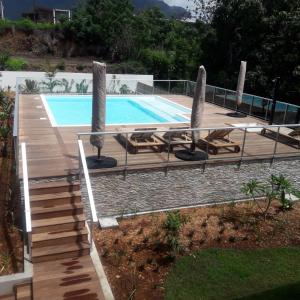 una piscina con tumbonas y una terraza de madera en Le Pacifik Kone, en Koné