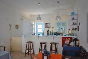 a kitchen with a counter and stools in a room at Aeolis Santorini in Perissa