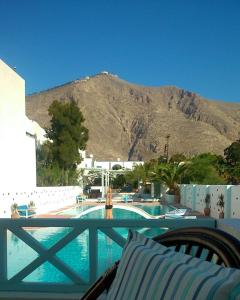 a view of a swimming pool with a mountain in the background at Aeolis Santorini in Perissa