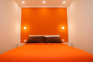 an orange bed with an orange wall in a bedroom at Los Rodeos Luxury Vivienda Vacacional in La Laguna