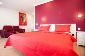 a red bedroom with a large bed and a chair at Los Rodeos Luxury Vivienda Vacacional in La Laguna
