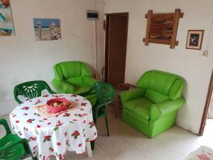 een eetkamer met groene stoelen en een tafel met een fruitschaal bij Los Lachos in Aguas Dulces