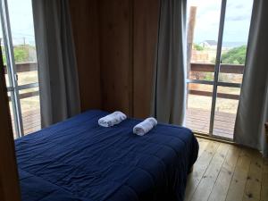 two towels on a bed in front of a window at Luna & Zoé in Barra de Valizas