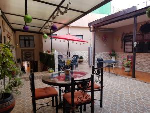 une terrasse avec une table, des chaises et un parasol dans l'établissement Hotel Nuevo Cupatitzio, à Uruapan del Progreso