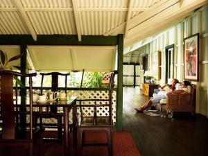 two people sitting on a couch in a living room at Pinctada McAlpine House in Broome