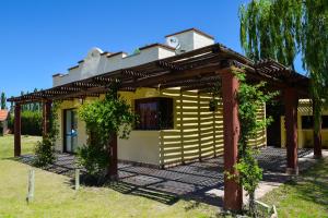 una casa con una pérgola delante de ella en Cabañas Puerta del Sol en San Rafael