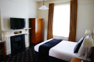 Tempat tidur dalam kamar di Highland House Boutique Hotel