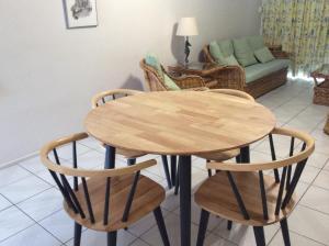 a wooden table and chairs in a living room at Kirrama 4 in Mission Beach