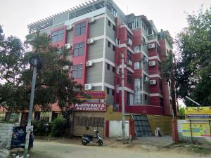 un edificio con una moto aparcada delante de él en Aishvarya Residency Coimbatore en Coimbatore