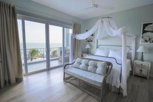 a bedroom with a bed and a balcony with the ocean at Serenity by the Sea in Mui Ne