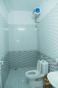 ein Badezimmer mit einem weißen WC und einem Waschbecken in der Unterkunft Gold Plus Hotel in Phong Nha