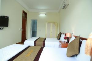 ein Hotelzimmer mit 2 Betten und einem TV in der Unterkunft Gold Plus Hotel in Phong Nha