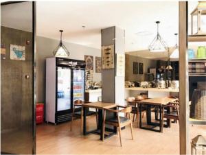 a dining room with tables and a refrigerator at James Joyce Coffetel Beijing Gulou street, Nanluoguxiang in Beijing