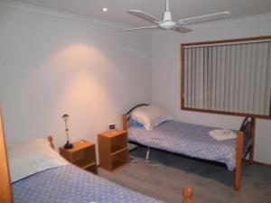 Un pat sau paturi într-o cameră la The Real McCoy Holiday Accommodation