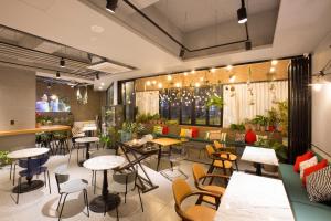 a restaurant with tables and chairs in a room at Bay Hound Hotel in Busan