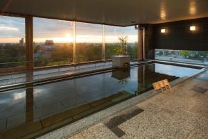 a swimming pool in a building with a view of the city at Okazaki New Grand Hotel in Okazaki