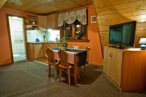 a kitchen with a table with chairs and a television at Willa Anna in Zakopane