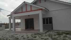 una pequeña casa blanca con techo rojo en MaiHomestay Seri Iskandar en Seri Iskandar