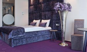 a bedroom with a bed and a vase with flowers at G Design Hotel in Ljubljana