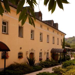 un gran edificio blanco con un porche delante en Landhaus Lockwitzgrund, en Lockwitz