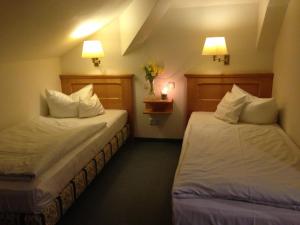a hotel room with two beds and two lamps at Landhaus Lockwitzgrund in Lockwitz