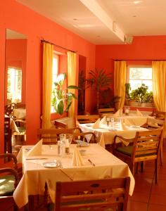 a restaurant with tables and chairs with orange walls at Landhaus Lockwitzgrund in Lockwitz