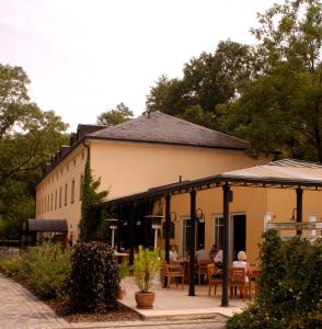 um edifício com pessoas sentadas em mesas à frente dele em Landhaus Lockwitzgrund em Lockwitz