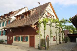 an old building with a brown roof on a street at Bioweingut und Ferienwohnung Kaufmann in Efringen-Kirchen