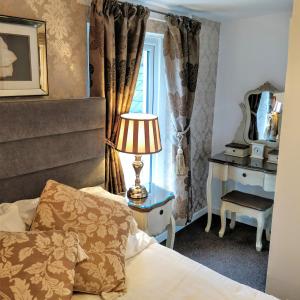 a bedroom with a bed and a lamp and a window at Number 43 in Derry Londonderry