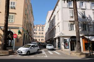 um carro branco estacionado numa rua da cidade com edifícios em LE PIGEONNIER Ajaccio em Ajaccio
