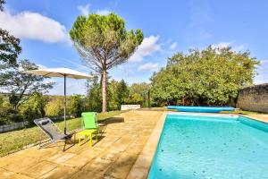 a swimming pool with two chairs and an umbrella at Les Terrasses De Chaumont 1 in Montsoreau