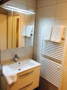 y baño con lavabo, espejo y toallas. en Landgasthof Schwanen, en Merenschwand