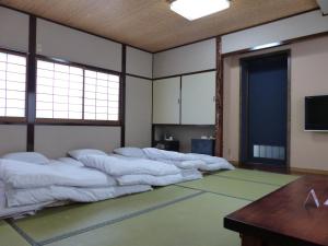 Un pat sau paturi într-o cameră la Minshuku Kuwataniya