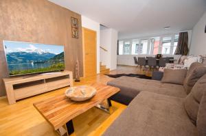 uma sala de estar com uma grande televisão de ecrã plano em Penthouse SEVEN by All in One Apartments em Zell am See