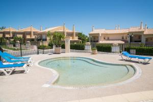 a swimming pool with two chairs and a house at Boavista Fairviews Village in Lagos