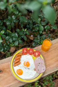 a plate with eggs and sausage and carrots on a table at P's cottage บ้านพักในสวนสวย in Trang