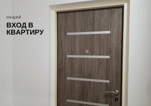 uma porta de madeira num quarto com uma placa em Комфортные мини-апартаменты студио на Ломоносова em Kiev