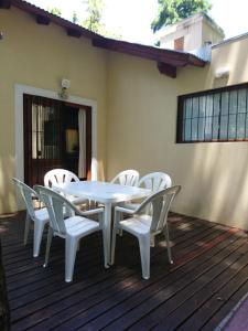 a white table and chairs on a deck at Ñande Roga in Mar de las Pampas